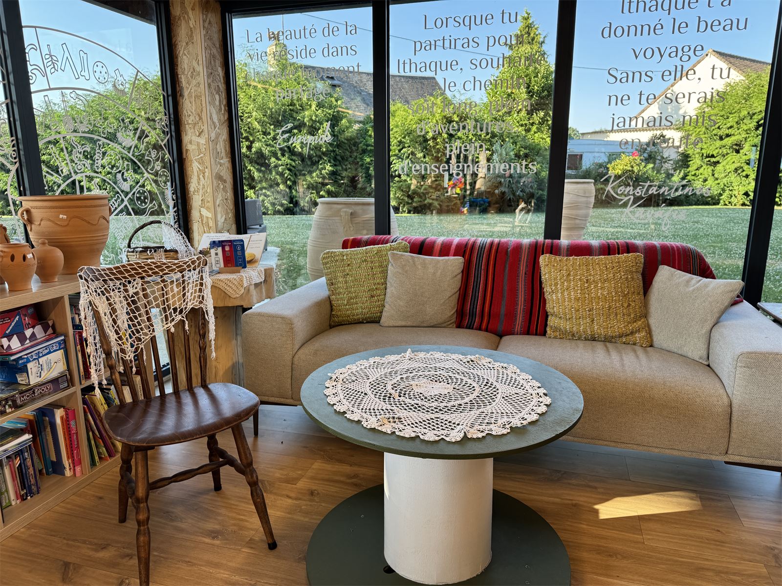Coin salon de la boutique de Messei, avec le poème d'Ithaque calligraphié sur les baies vitrées